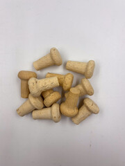 Top-down view of a group of natural cork bottle stoppers lying on a white background.