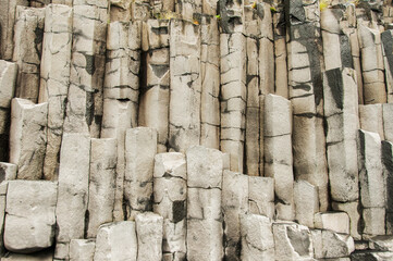 Reynisfjara, black sand beach, detail of escarpment with numerous basalt columns, in Iceland