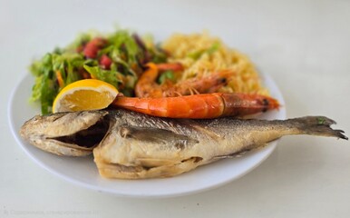 Fried fish with side dish on a plate. Fish day.