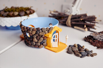 DIY house project made from stones and plastic bowl.
Creative kids craft with natural materials and playful design.
Handmade decoration inspires imagination and home creativity.
