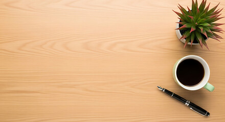 Overhead view of a wooden desk with coffee, pen, and a succulent plant.