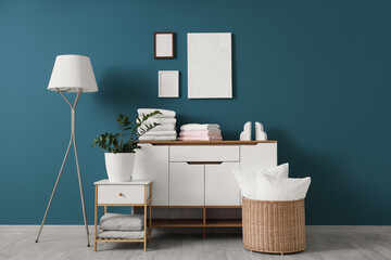 Interior of room with commode, bed sheets and lamp