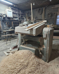 Woodworking workshop with planer machine and sawdust
Carpentry shop interior with woodworking tools and materials