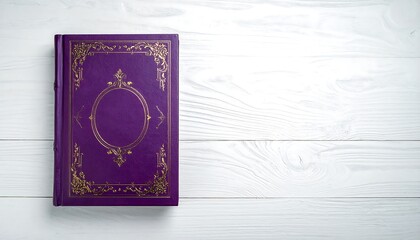 An overhead shot showcases a closed, hardcover book with a luxurious purple cover and gold embellishments on a white wooden backdrop