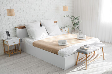 Interior of hotel room with bed, soft bench and lamps