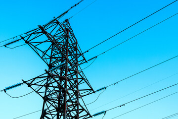 the steel support of high-voltage power lines against the background of the blue sky