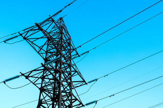 the steel support of high-voltage power lines against the background of the blue sky