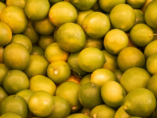 A large pile of fresh green limes creating a vibrant background