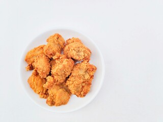 Breaded fried chicken in a white plate on a white background.