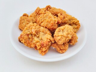 Breaded fried chicken in a white plate on a white background.