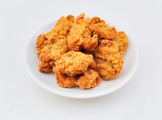 Breaded fried chicken in a white plate on a white background.