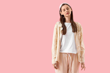 Female sleepwalker in pajamas on pink background
