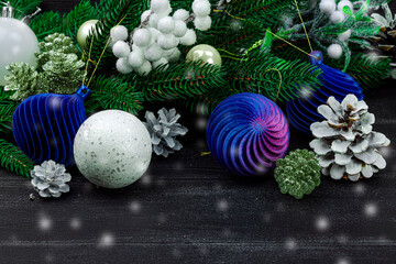 Happy New Year background. Festive Christmas baubles, evergreen branches, pine cones, snowy berries