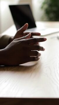 Extreme close-up video of diverse hands in neutral professional attire resting thoughtfully on a sleek minimalist desk, subtly shifting with deep concentration and strategic planning, in a modern