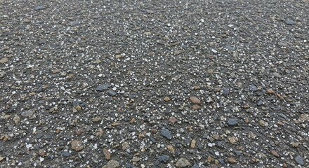 Close-up of a rough asphalt surface with small stones.