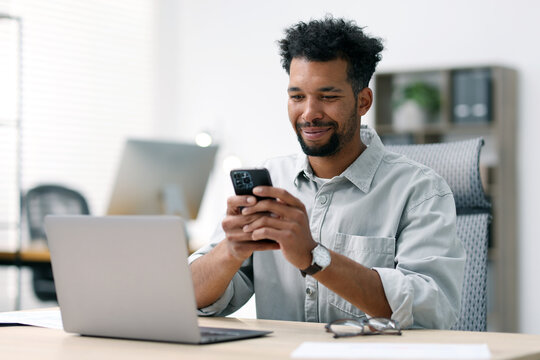 Man using smartphone at table in office