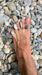 Rocks between toes in rocky beach Kalamata Greece