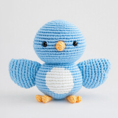 A charming crocheted bluebird with its wings spread wide