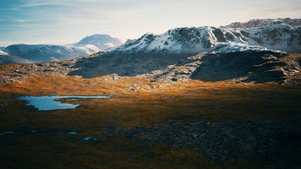 This breathtaking scene captures a vast mountainous terrain featuring snow capped peaks and calm water pools. The landscape is illuminated by the soft light of dusk, showcasing natures beauty.