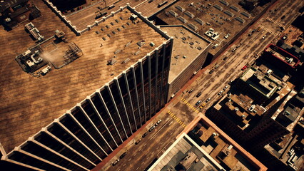 High above bustling city streets, tall buildings rise against the blue sky. Cars and pedestrians engage in their daily routines, creating a vibrant urban atmosphere.