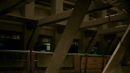 In a dimly lit industrial area, a unique blend of metal and concrete structures creates a captivating atmosphere. Shadows play across the surfaces as details emerge in the low light.