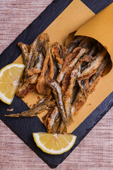 Cuoppo napoletano ripieno di alici fritte mentre vengono condite con limone spremuto al momento