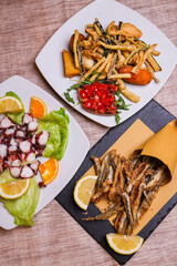 Cuoppo di alici fritte, polpo all'insalata e piatto con verdure fritte, bruschetta al pomodoro e fritto misto napoletano serviti come antipasti in una trattoria