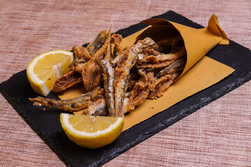 Cuoppo napoletano ripieno di alici fritte mentre vengono condite con limone spremuto al momento