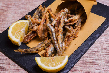 Cuoppo napoletano ripieno di alici fritte mentre vengono condite con limone spremuto al momento