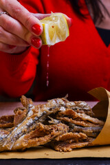 Cuoppo napoletano ripieno di alici fritte mentre vengono condite con limone spremuto al momento