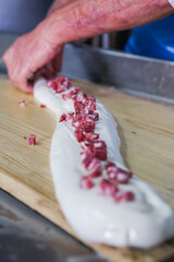 Operaio di un caseificio mentre prepara la mozzarella di bufala campana ripiena a mano 