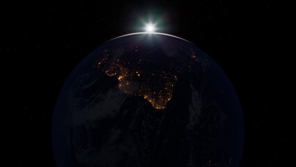 This captivating scene depicts Earth from space at sunrise, showcasing the glowing lights of India beneath the dark expanse. The interplay of light highlights the beauty of our planet.