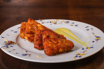 Rosti di pătate con speck e provola fritti e serviti come antipasto in un pub