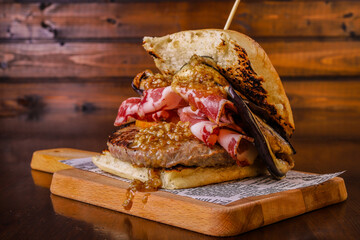 Panino da pub ripieno di hamburger di carne, melanzane grigliate, coppa di maiale, e provola affumicata servito un pub