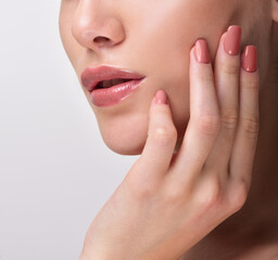 Beautiful Young Woman with Clean Fresh Skin. Close up Portrait.  Fashion Model Girl Face. Perfect Skin. Professional Makeup. Fashion shiny highlighter on skin, sexy gloss lips. Perfect manicure.