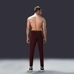 Fototapeta premium Shirtless athletic male model standing in studio, showcasing muscular physique, fitness body, and healthy lifestyle on dark background.