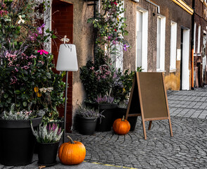 Entering A Cafe With Fall Decorations, Pumpkins, And A Wooden Chalkboard Menu