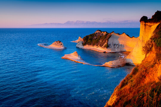 Cape Drastis rock formations on island Corfu at sunset, Greek coastline landscapes with rocks. Popular viewpoint on Ionian Islands.