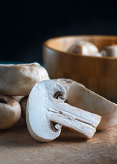 Sliced White Mushroom on Rustic Surface with Wooden Bowl