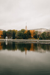 A view of a building with a spire across the river in Minsk