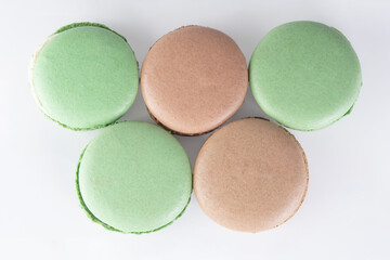 Sweet dessert composition: pastel macaron on light background, backdrop.
