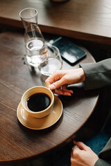 A cup of coffee in a girl's hands