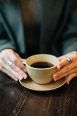 A cup of coffee in a girl's hands