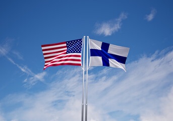 flags of  finland and United States of America over blue sky background.