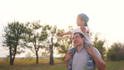 Father carries son on his neck walking in the park. happy family kid dream concept. father spends time with his child son outdoors father's day. father lifestyle carries son on his neck at sunset