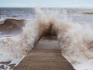 Large wave crashing onto breakwater in Devon