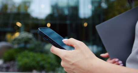 Close up of woman hand use phone. Hand of woman using texting mobile phone or chat. Outdoors