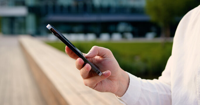 Close up of males hands use mobile phone outdoors