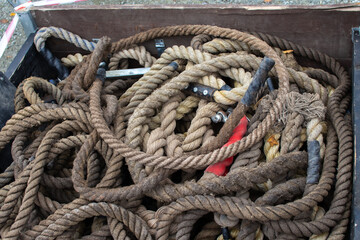 Ropes coiled and tangled in a wooden cart at a construction site in a busy 