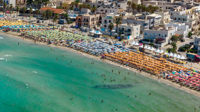 Aerial view of umbrellas on the beach of San Vito Lo Capo, a tourist destination in the province of Trapani, Sicily, Italy. It overlooks the Mediterranean Sea and is visited by tourists every summer.